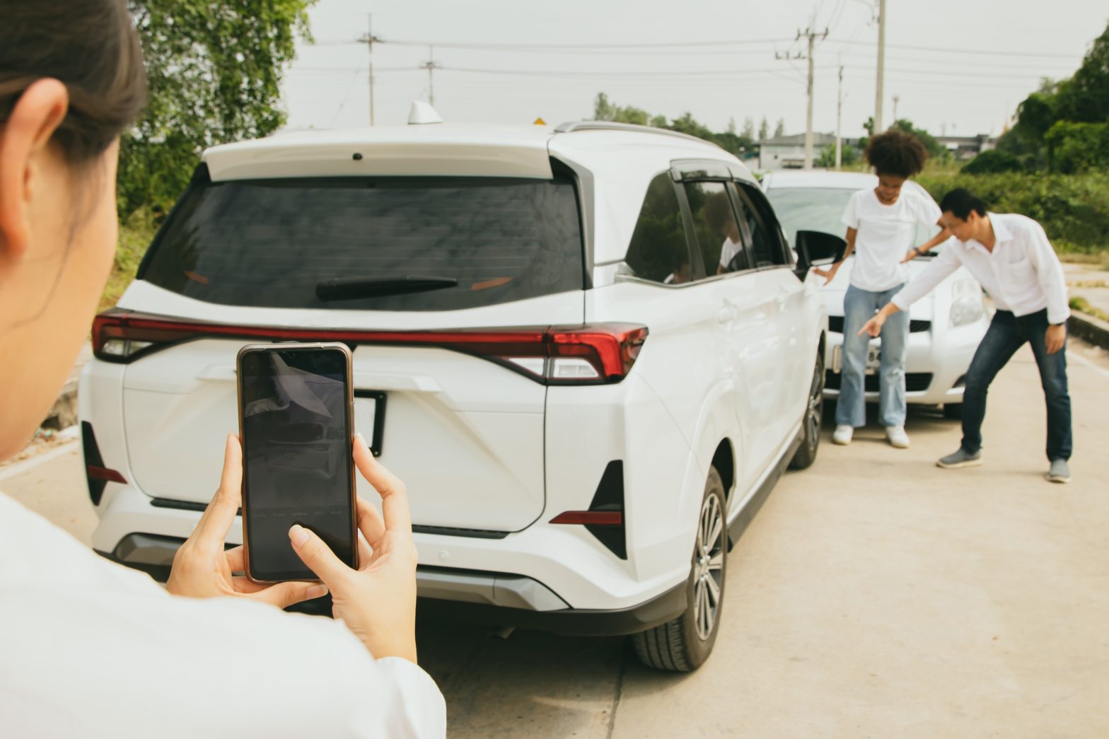A person takes a photo of a minor car accident involving two vehicles, for injury settlement meet with Smithfield Car Accident Attorney.